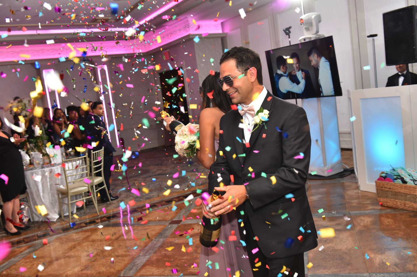 Groom celebrating in a confetti shower on the dance floor
